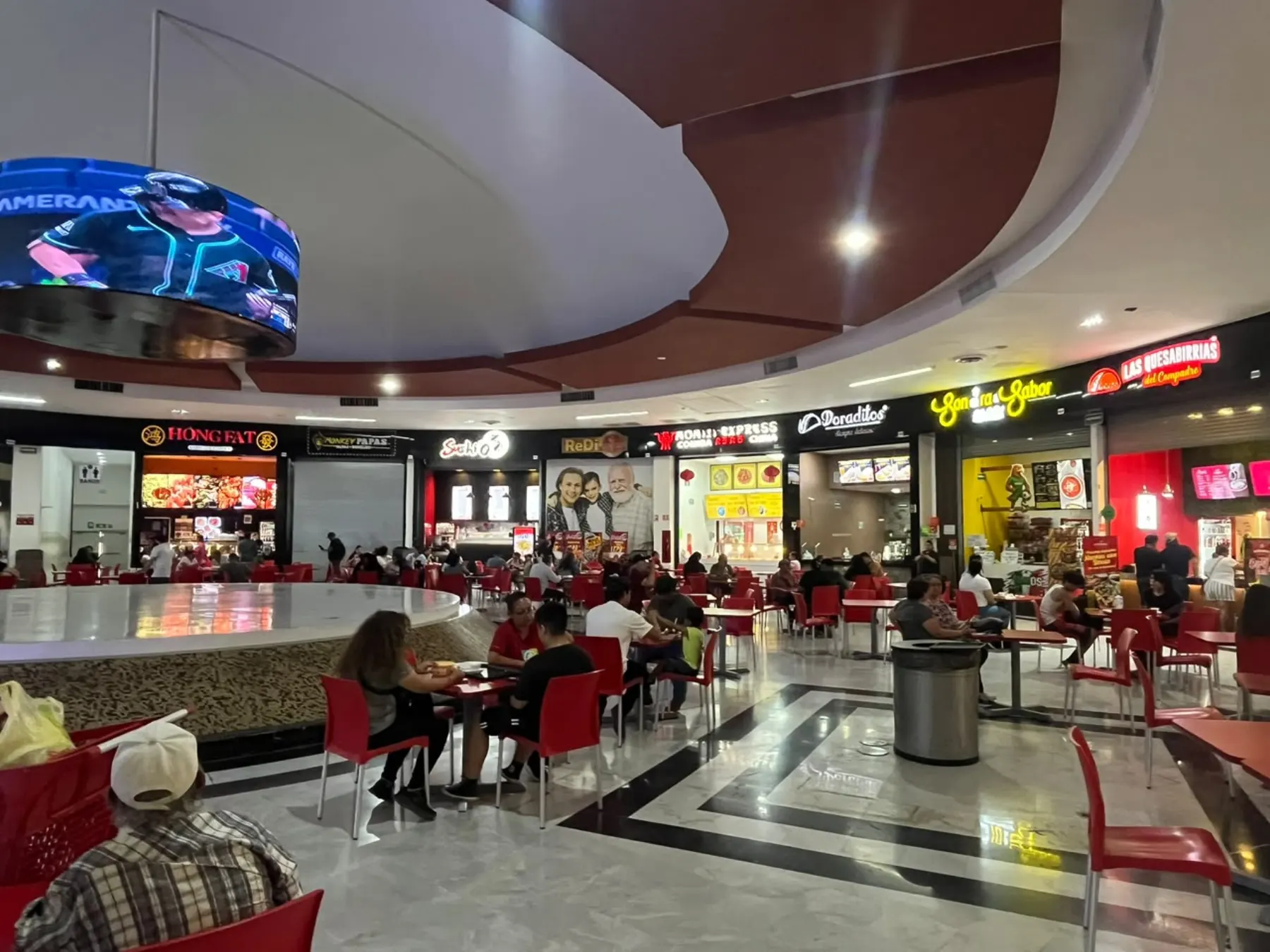 Plaza de comida de SunMall con mesas y locales de comida rápida